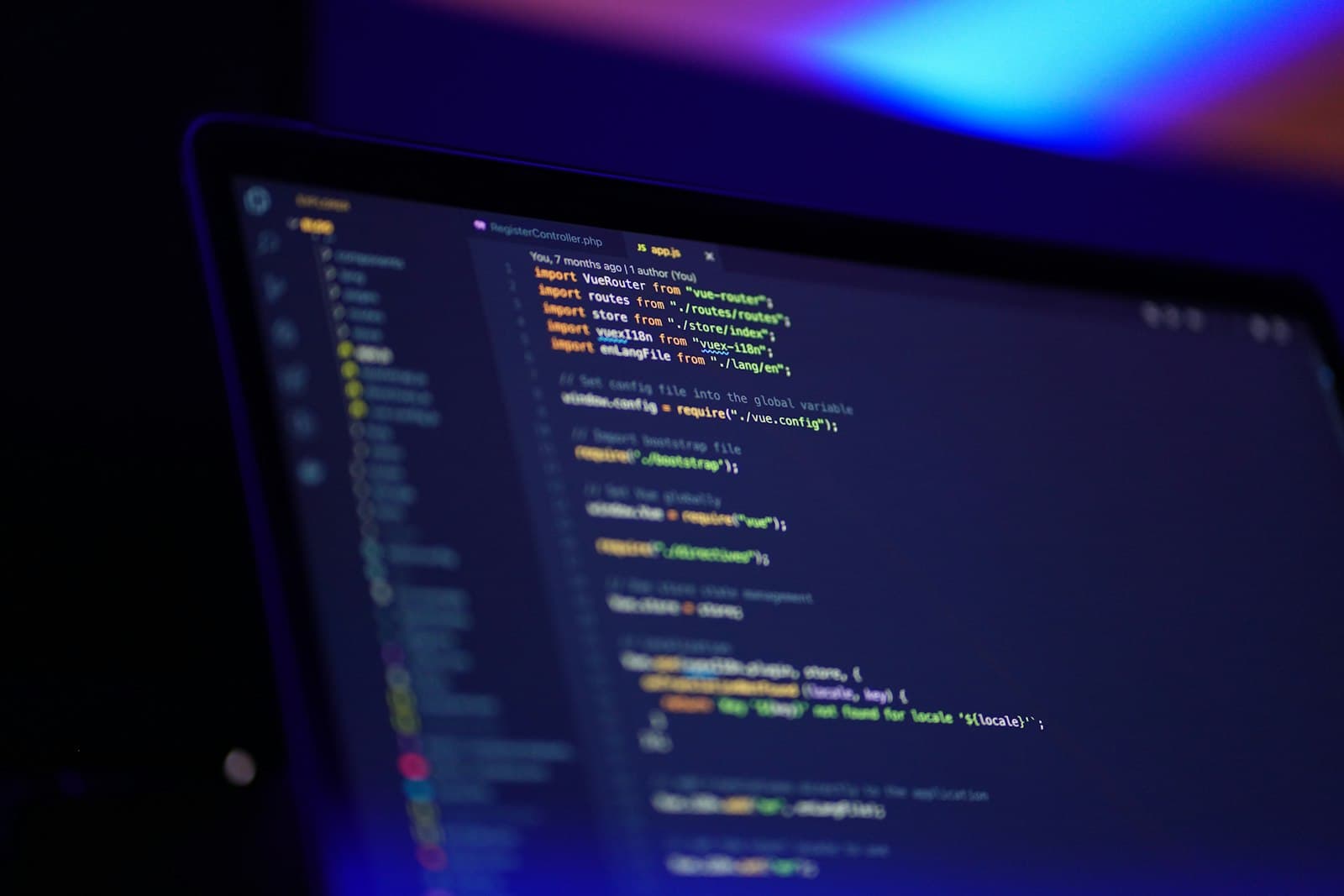 Laptop mit farbigem Quelltext in einem dunklen Raum